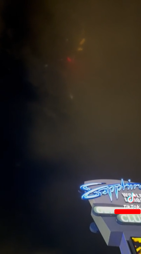 Screenshot from a TikTok showing lights above Vegas, they're not in any visibly symmetrical order and are quite curved, one is red and the rest are more orange in colour