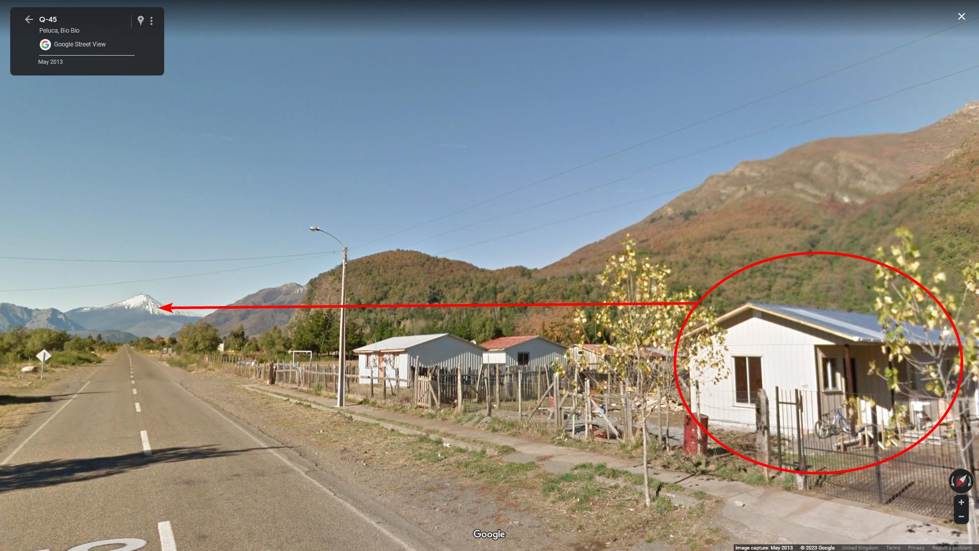 An image taken from google maps street view showing a red circle around a house or small building, and an arrow coming from that circle pointing towards Volcano Antuco